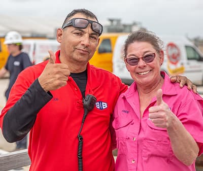 Two S&B employees giving a thumbs up at a volunteer event