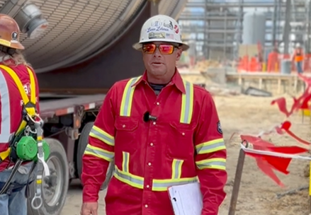 S&B's Lance Lehman wearing a red safety jumpsuit while walking through a project site
